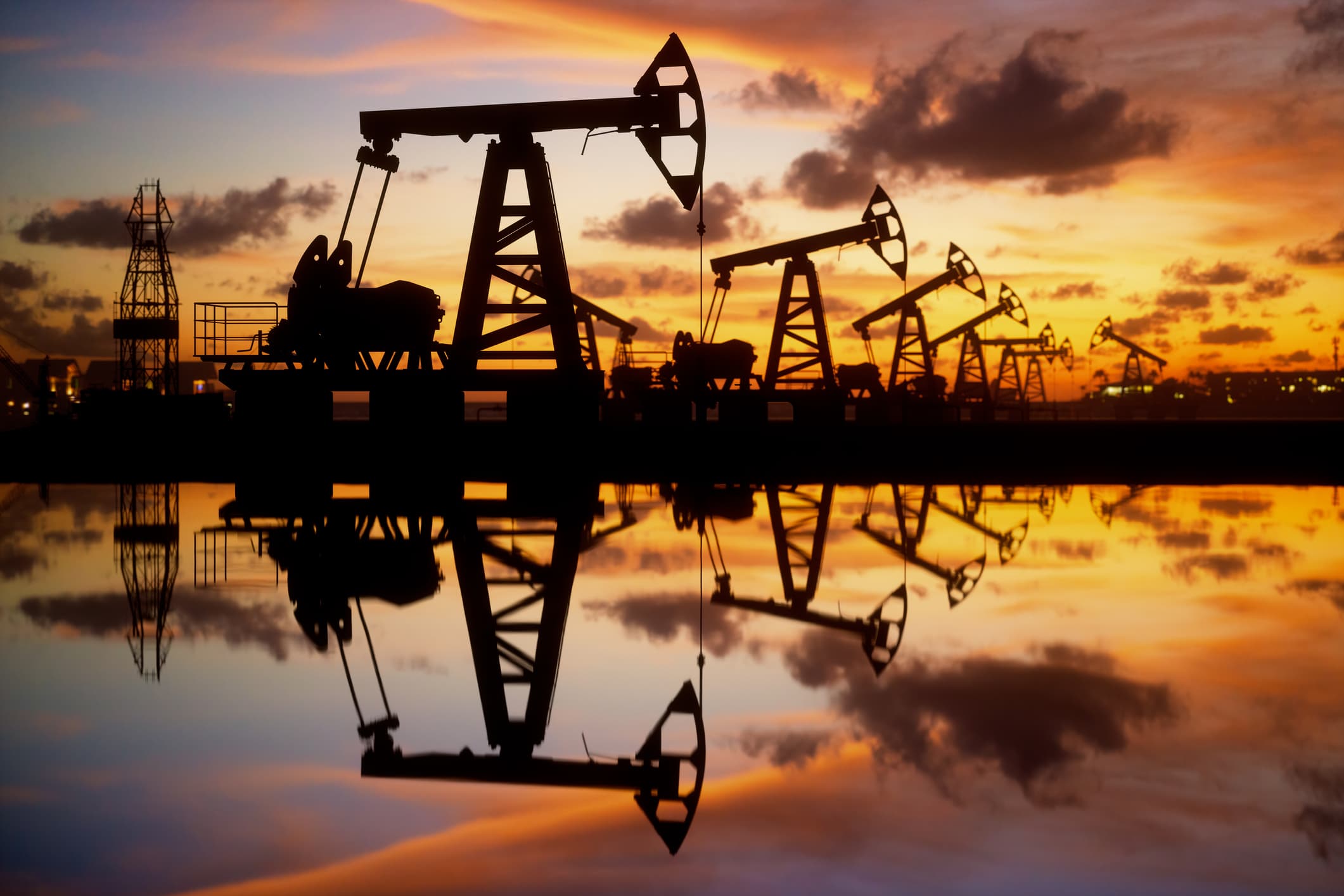 107065218 1653293244892 gettyimages 1323151704 oil pumps and rig at sunset